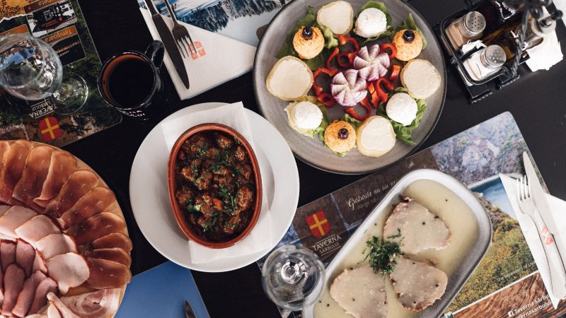 Black table adorned with a variety of food and beverages.